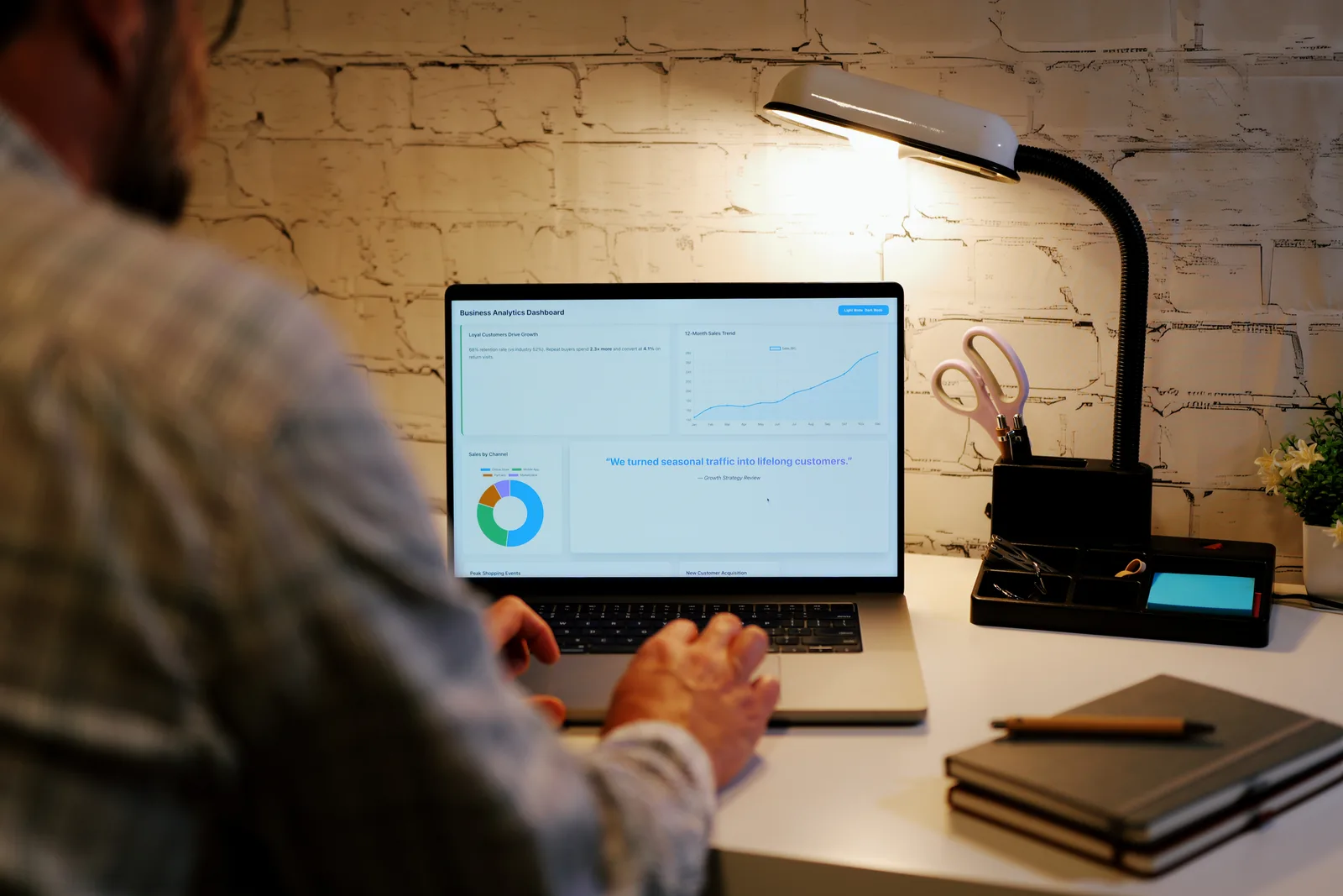 Solo software founder checking trial signups and revenue on a laptop at a home office desk