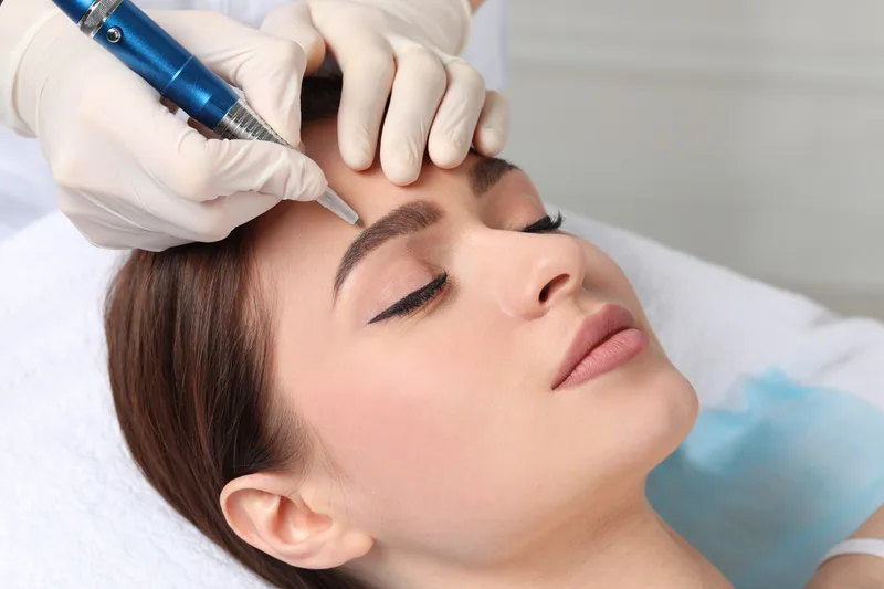 Permanent makeup artist microblading a client's eyebrows
