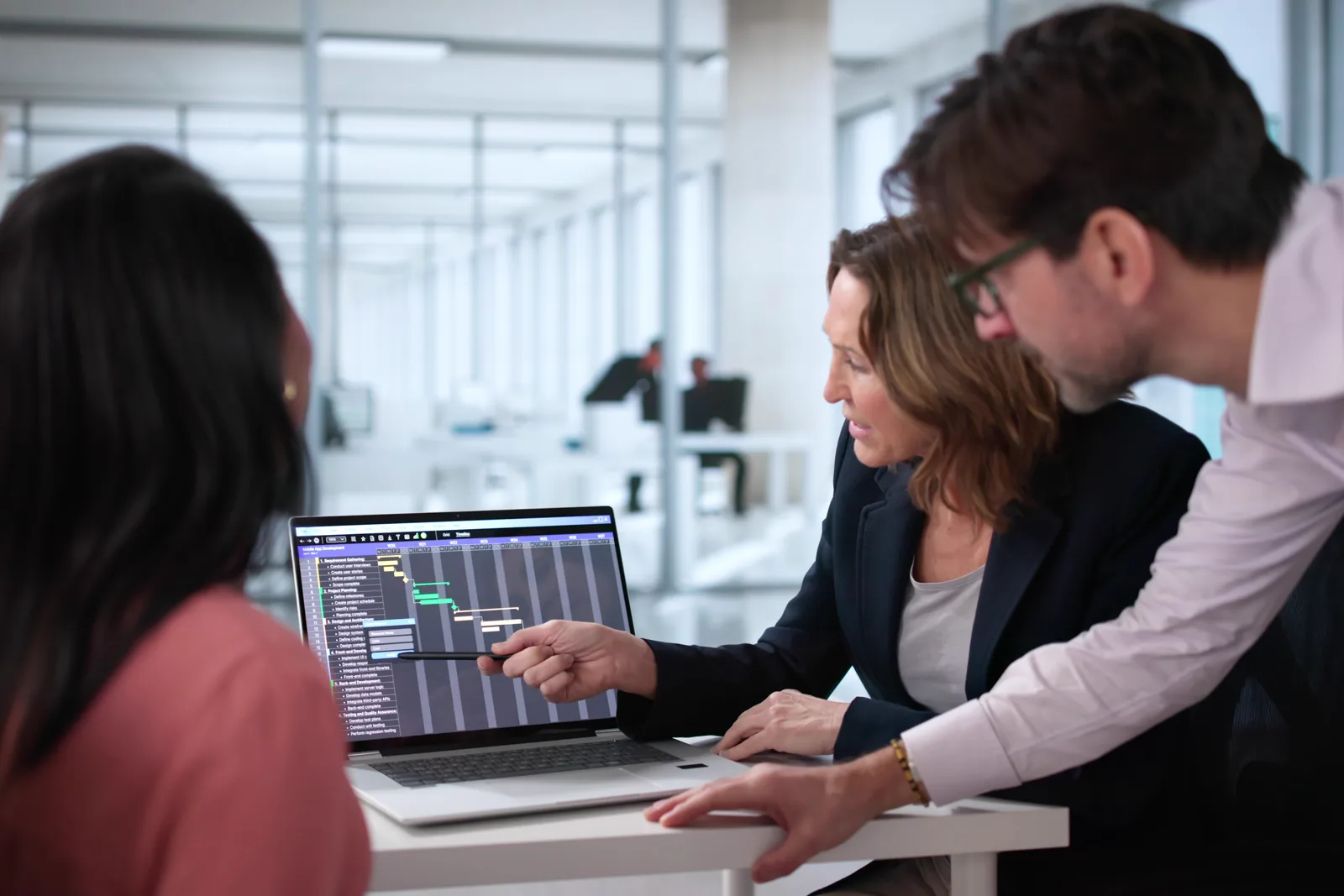 ML engineering team reviewing model training and deployment metrics together on a monitor in their office