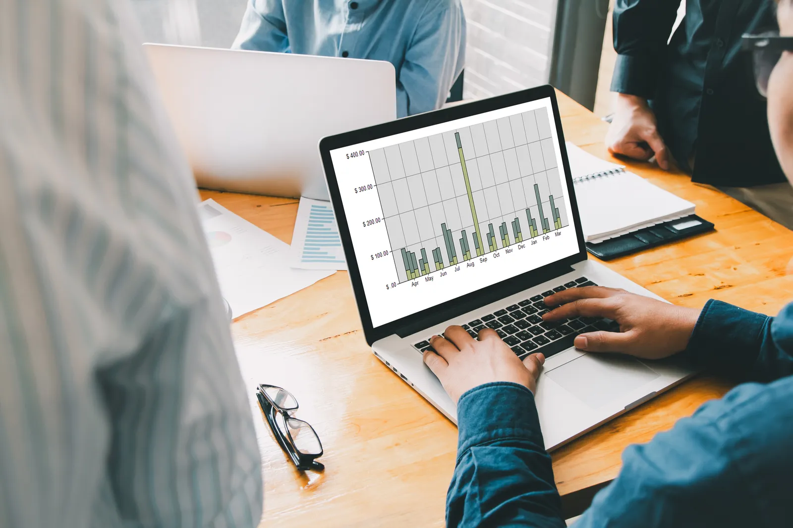 Utility billing software team reviewing a city account dashboard together on a laptop in an office