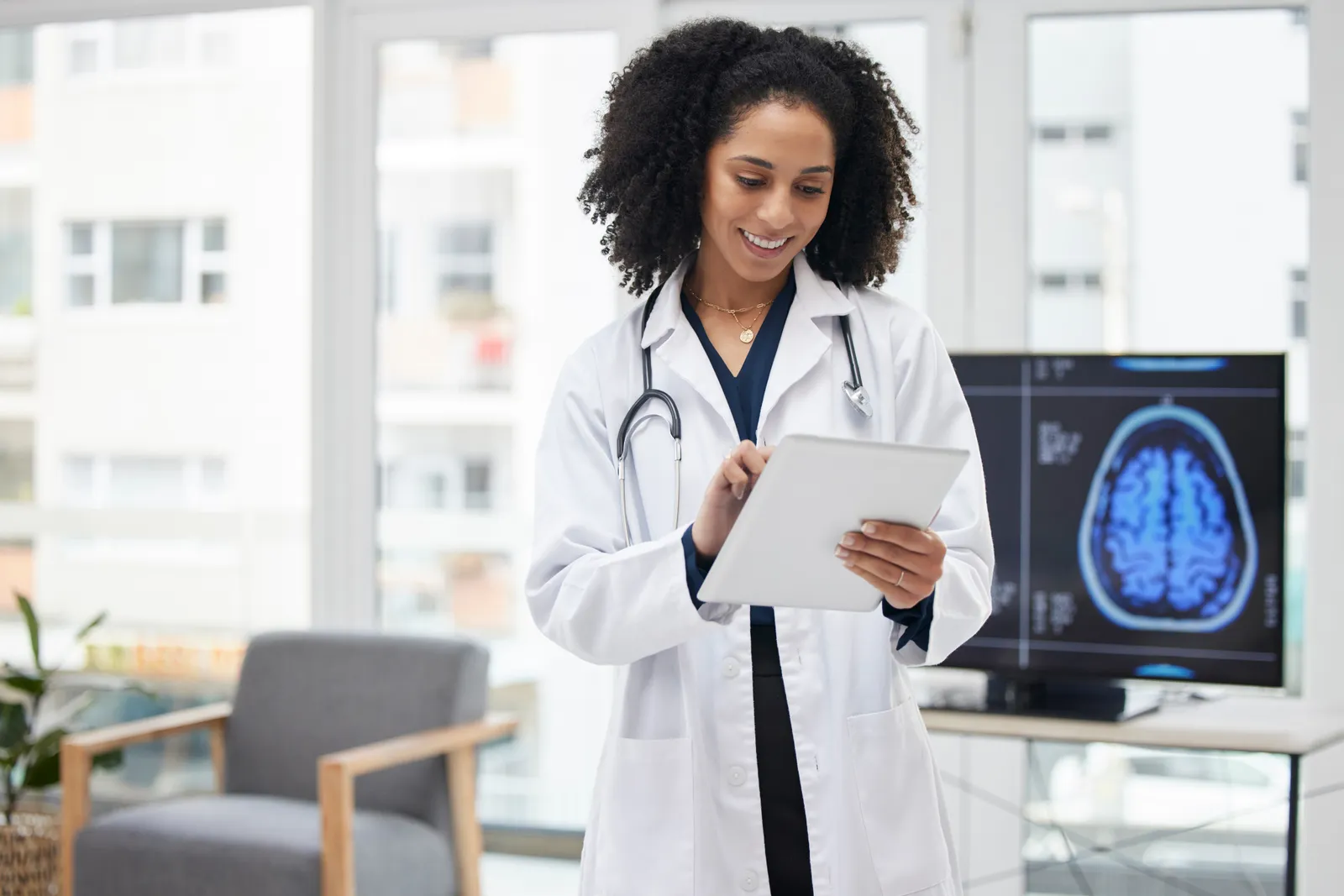 Neurosurgeon pointing to a brain MRI scan while discussing treatment options with a patient in an exam room
