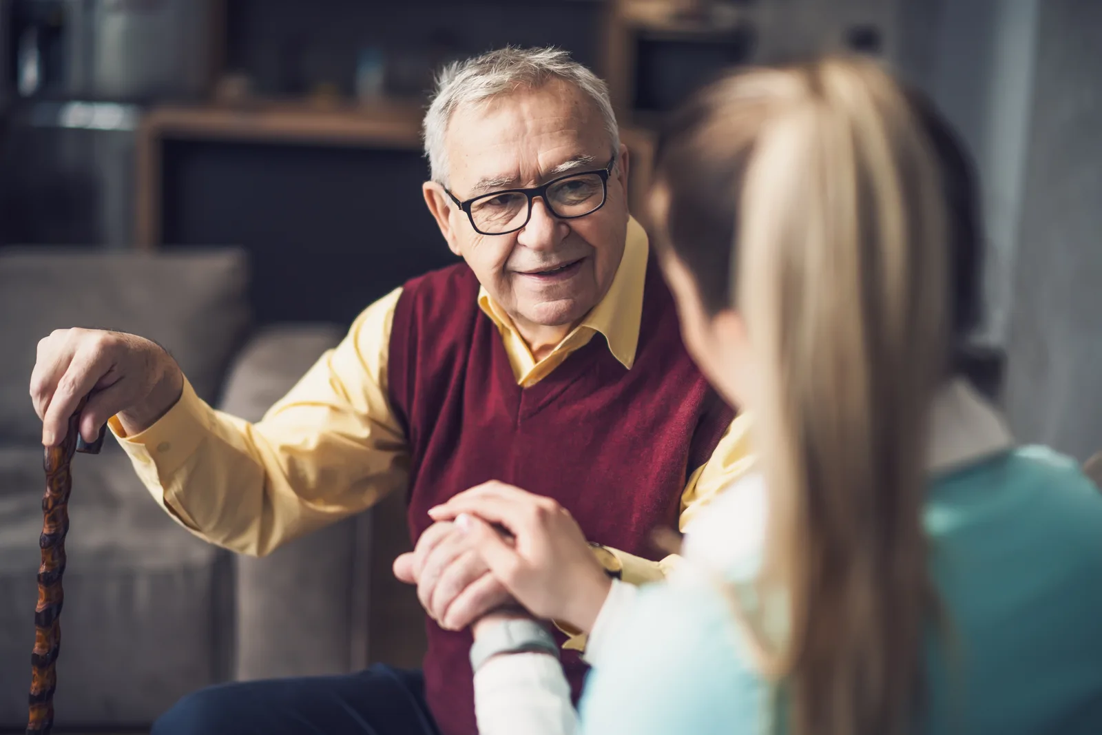 Nursing home abuse attorney reviewing a resident's medical records and injury photographs with an adult daughter at a law office conference table