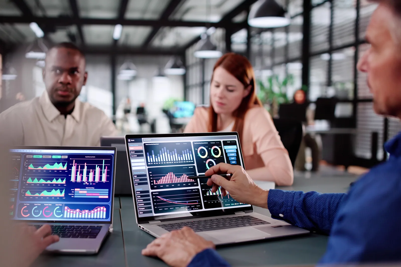 Open-source software team reviewing self-hosted deployment and paid-upgrade numbers together at a laptop in their office