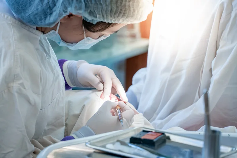 Oral surgeon treating a patient in a dental clinic