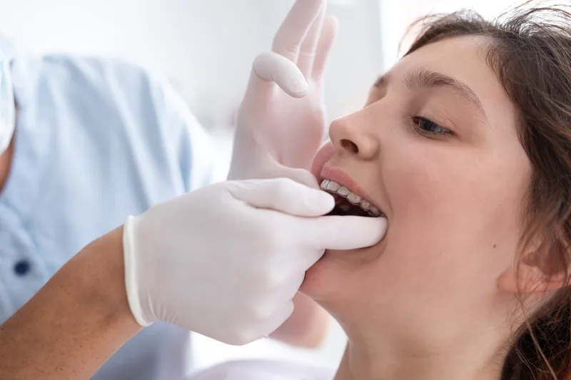 Orthodontist consulting with a teenage patient about braces