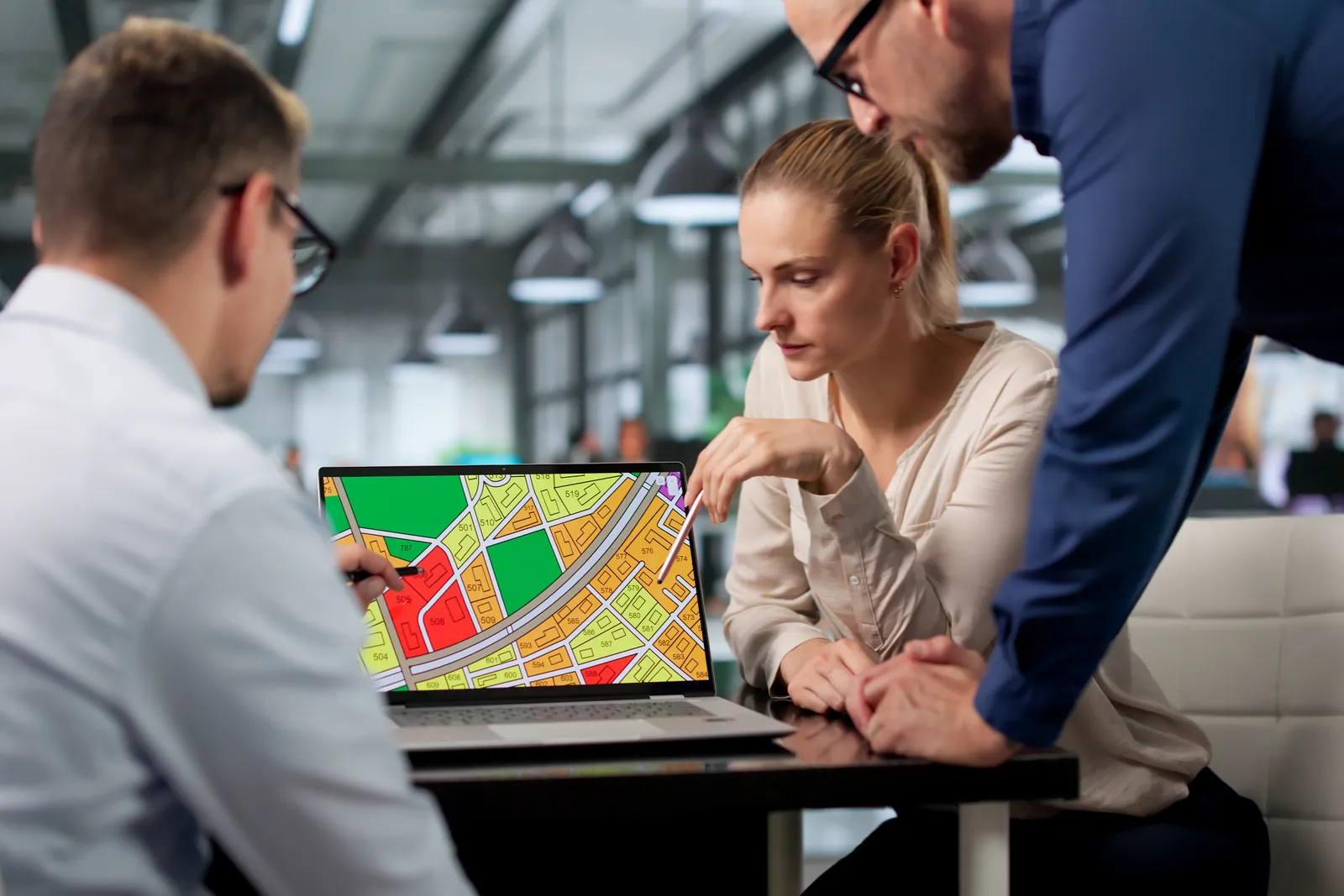 Parking management software product team reviewing a live occupancy map and enforcement dashboard on a laptop in their office