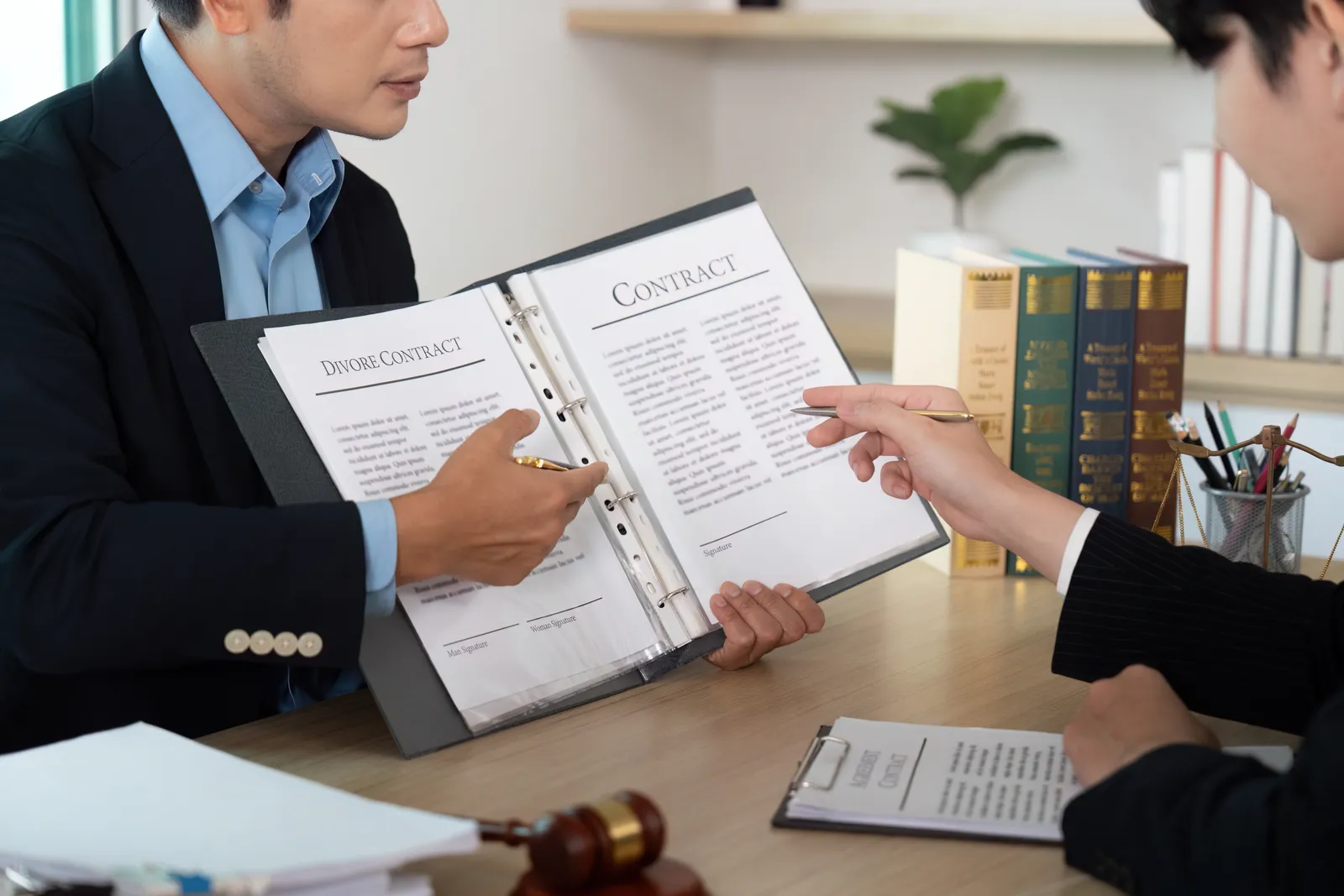 Paternity attorney reviewing DNA test paperwork with a father at her office desk
