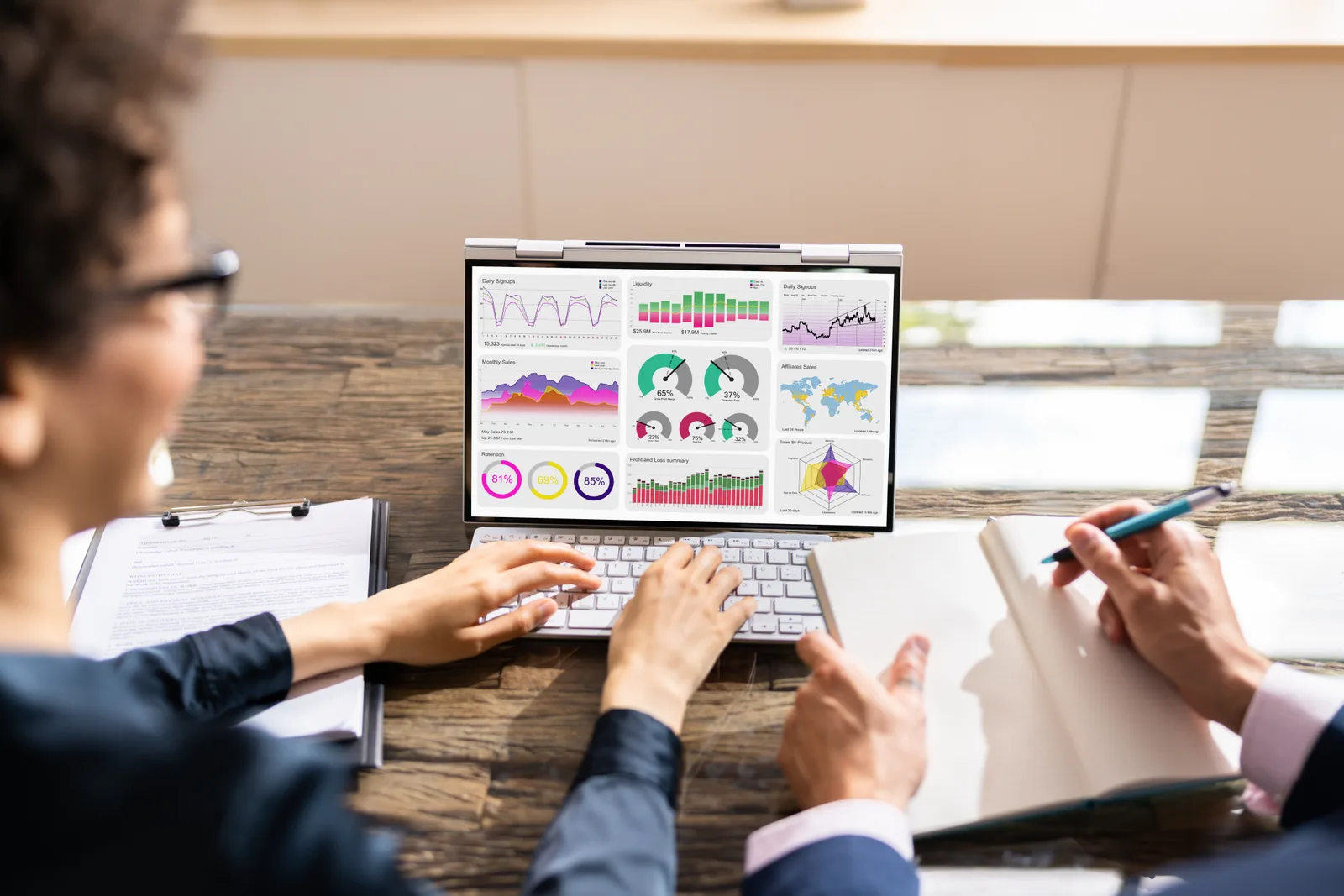 Payroll software team reviewing a client's pay-run dashboard together on a laptop in their office