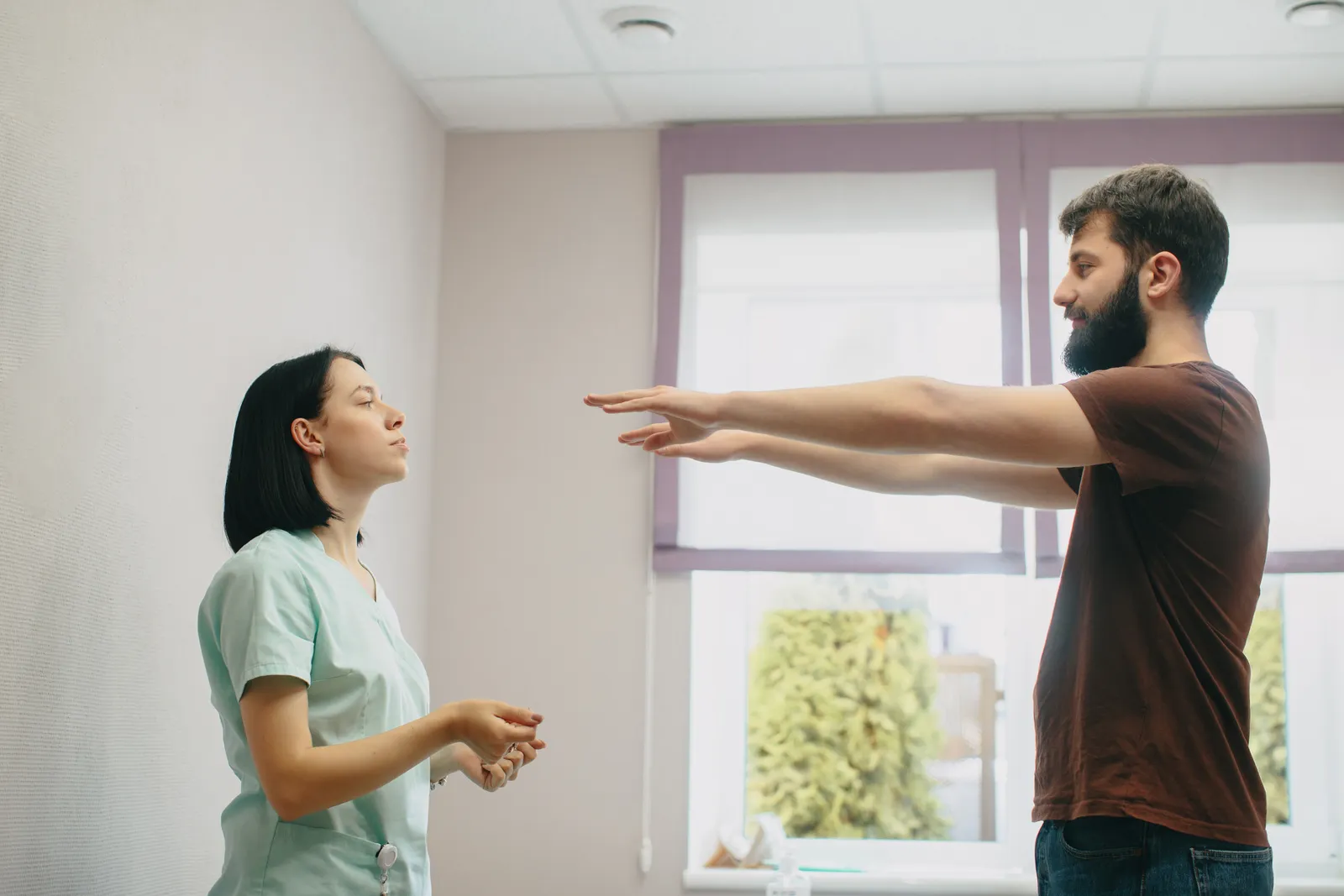 Physical therapist guiding a patient through an exercise in a treatment room