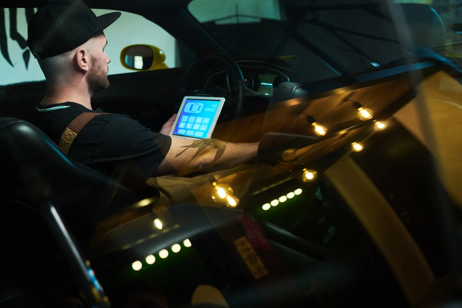 Technician running diagnostics from a tablet inside a performance car