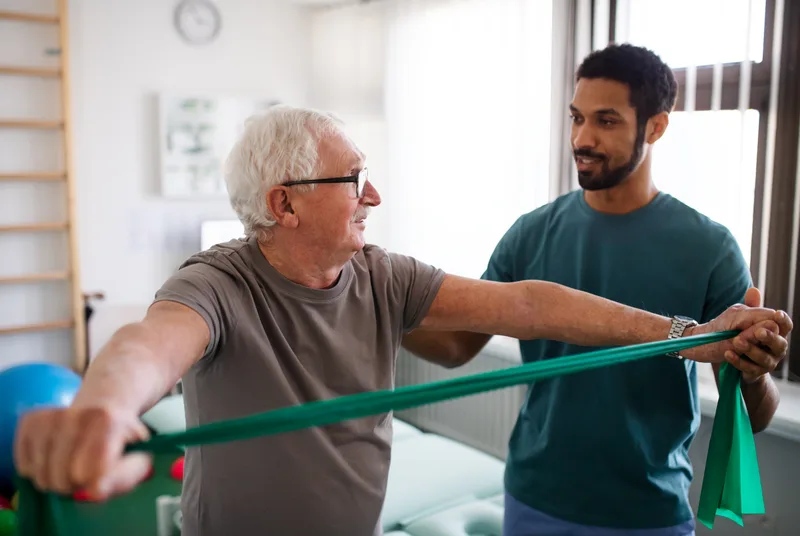 Physical therapist guiding a patient through a rehabilitation exercise in a clinic