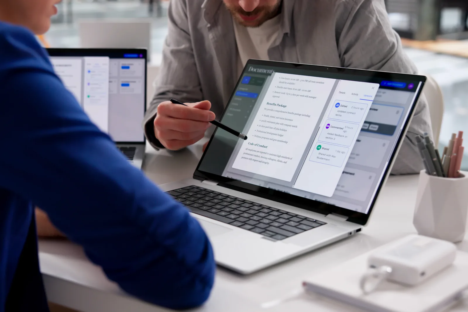 PLG software team reviewing free-trial signup and activation dashboards together on a laptop in their office