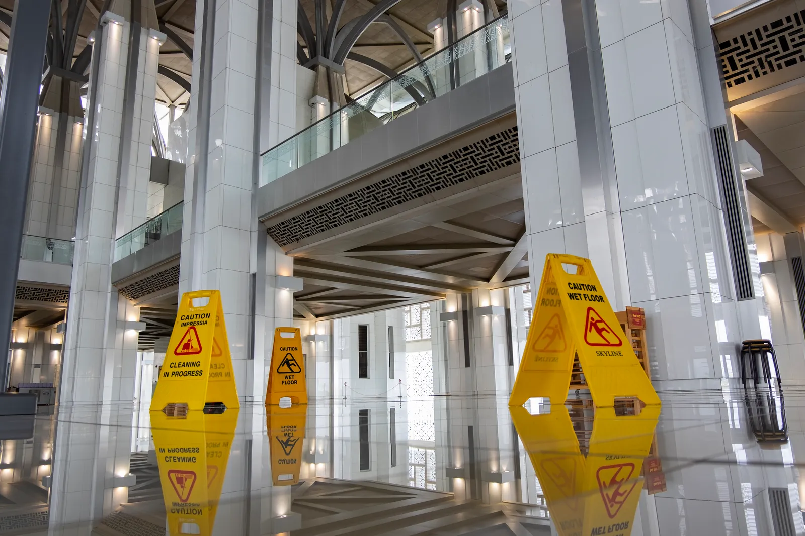 Yellow wet-floor caution signs in a commercial building lobby