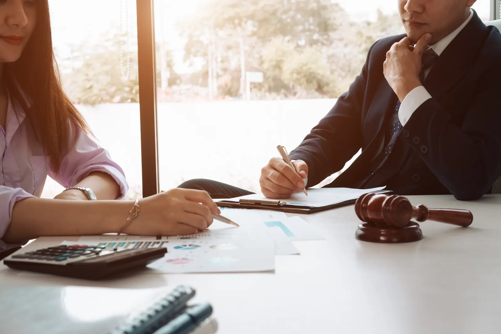 Probate litigation attorney reviewing a contested will and estate documents with a client at a law office conference table