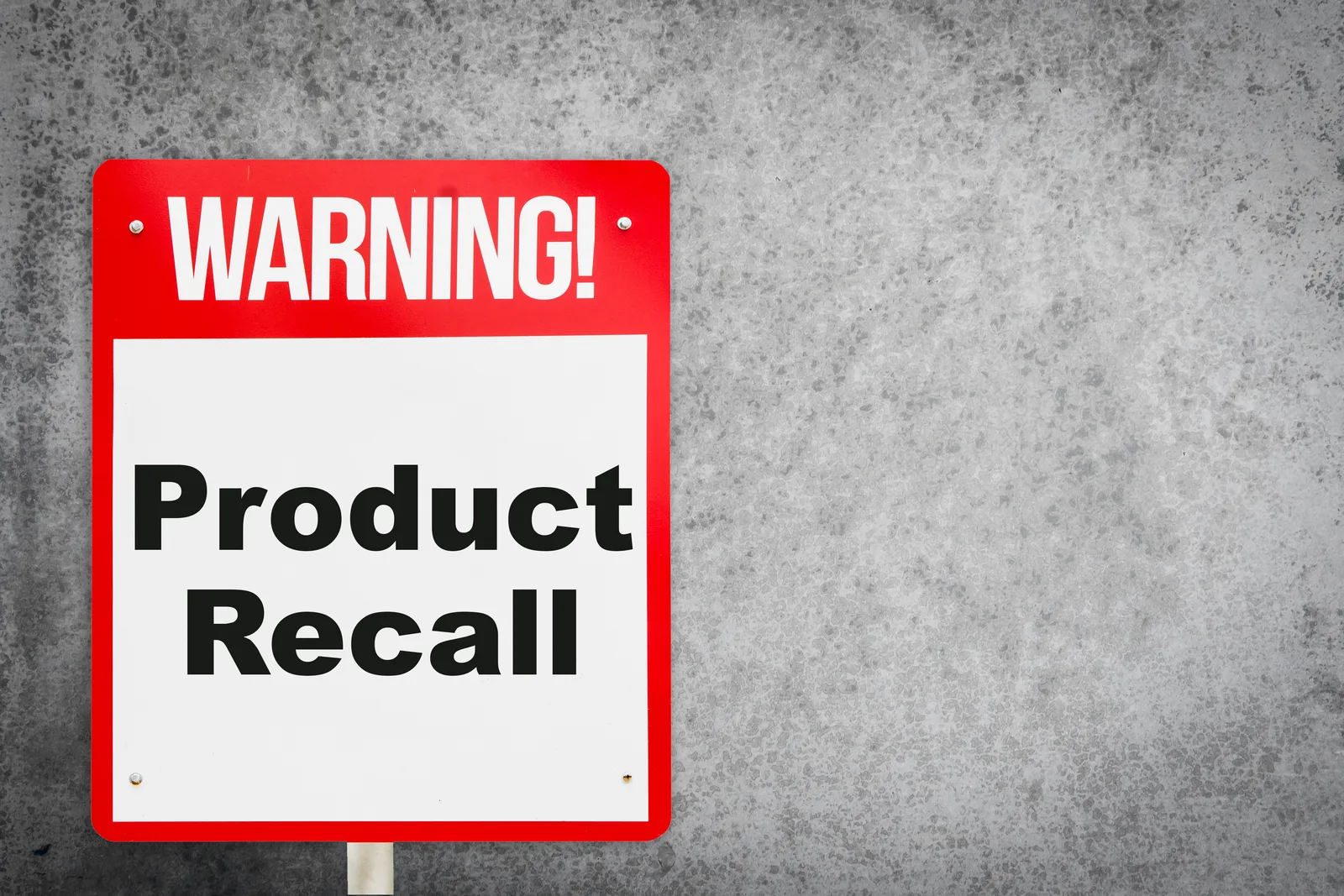 Product liability attorney examining a defective product with an injured client at a law office conference table