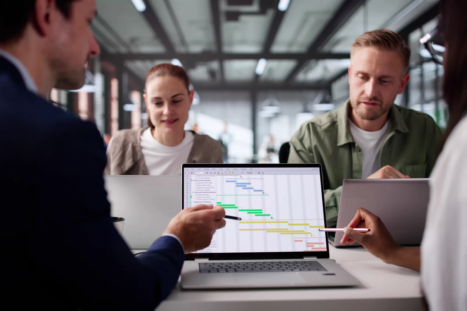 Property management software team reviewing rent-roll and maintenance-request dashboards together at a laptop in their office