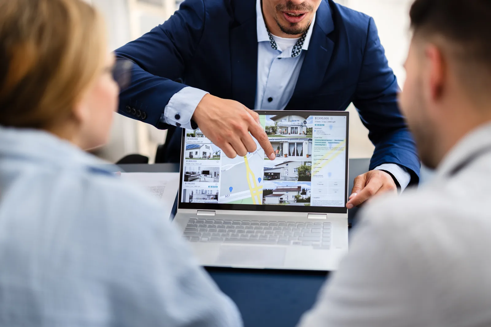 PropTech product team reviewing a property-management dashboard together at a laptop in their office
