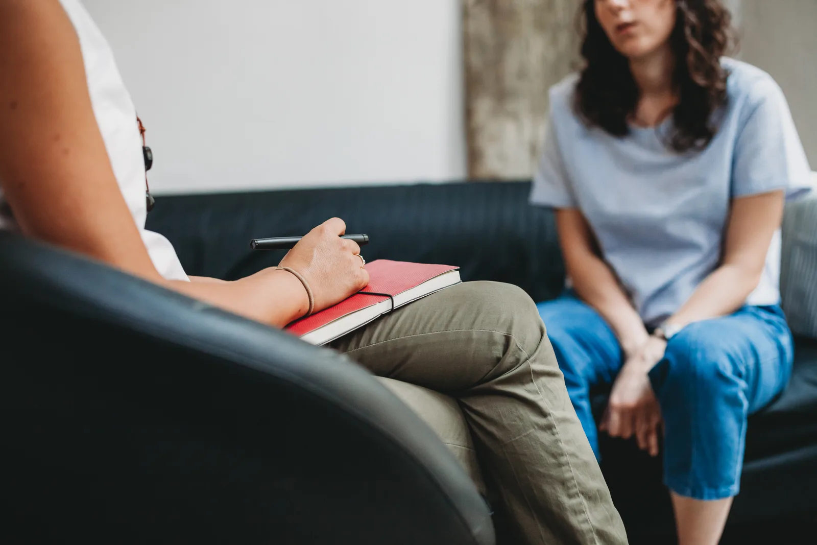 A psychologist reviewing notes with a client during a session in a calm, private office