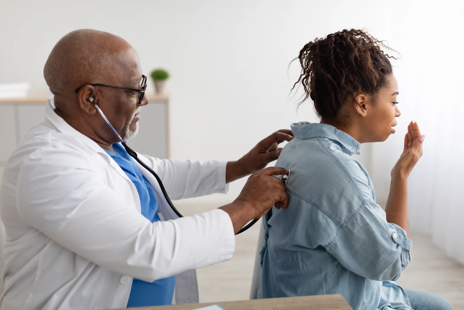 Pulmonologist listening to a patient's lungs with a stethoscope during an office exam