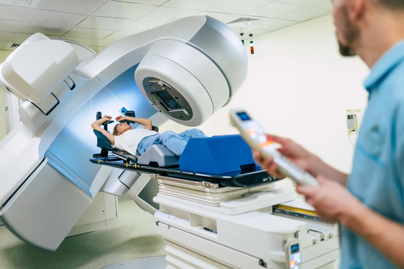 Radiation therapist positioning a patient under a linear accelerator before a treatment session