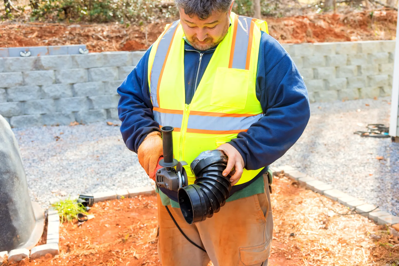 Technician fitting the fan and ducting for a home radon mitigation system