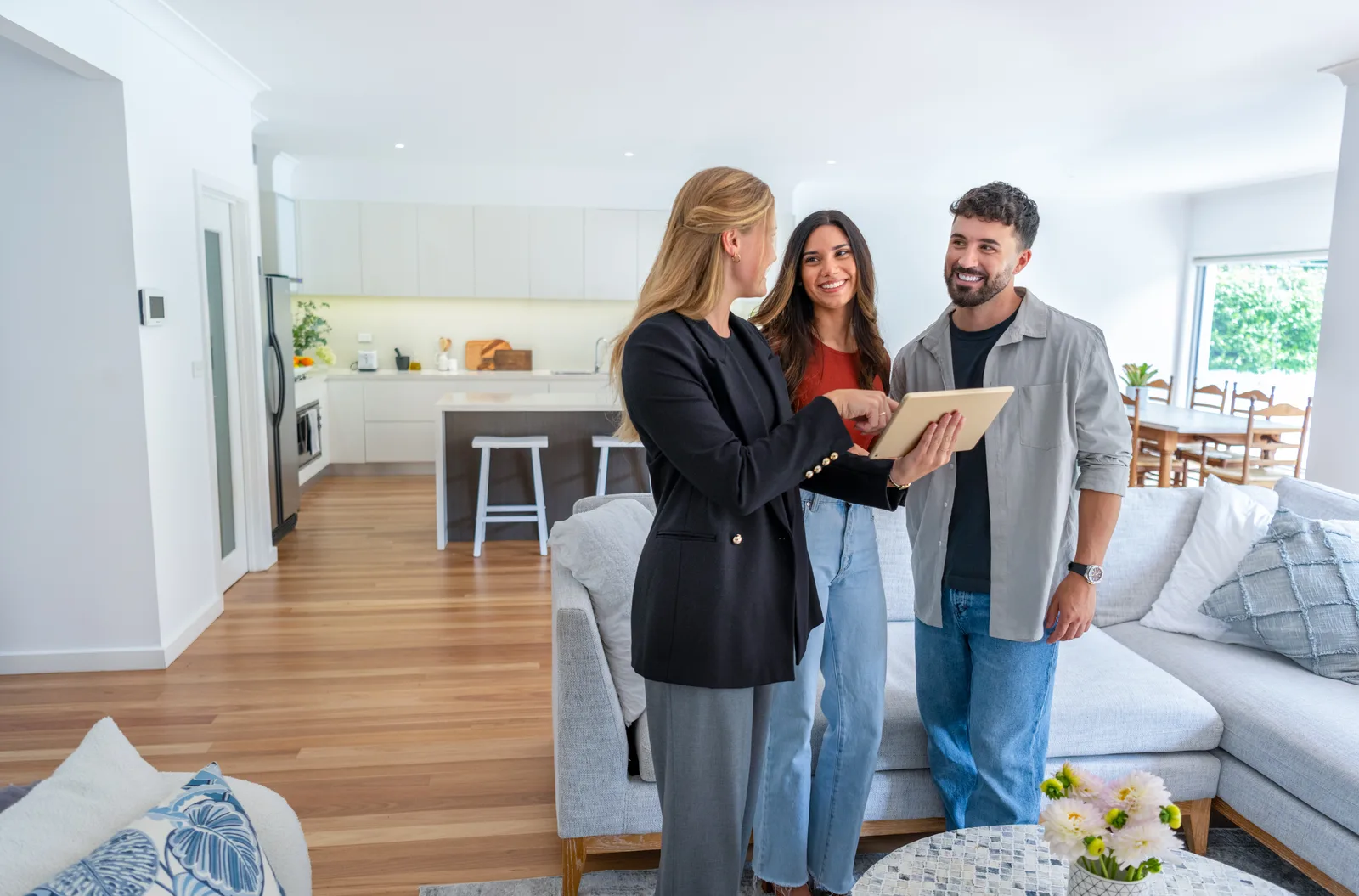 Real estate agent giving a smiling couple a tour of the kitchen in a home for sale