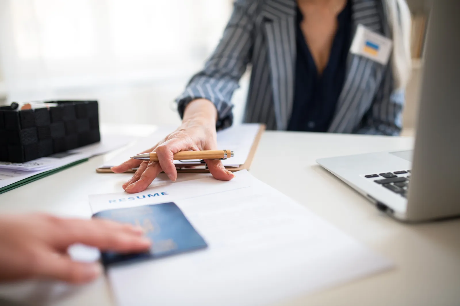 Hands reviewing a visa application form and passport at a desk