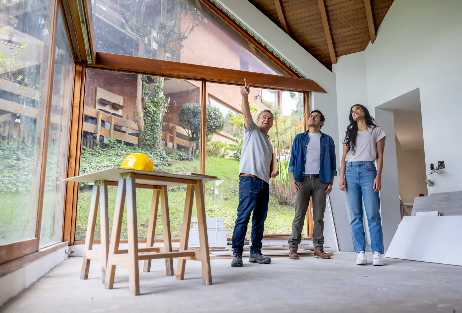 Remodeling contractor walking homeowners through renovation plans at their kitchen table