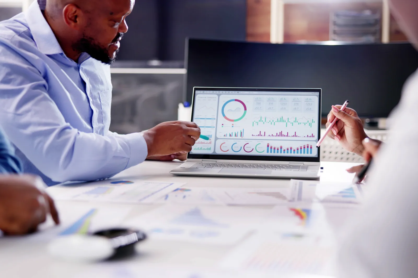 Data engineer and revenue operations lead reviewing a warehouse-to-CRM sync dashboard together on a laptop in their office