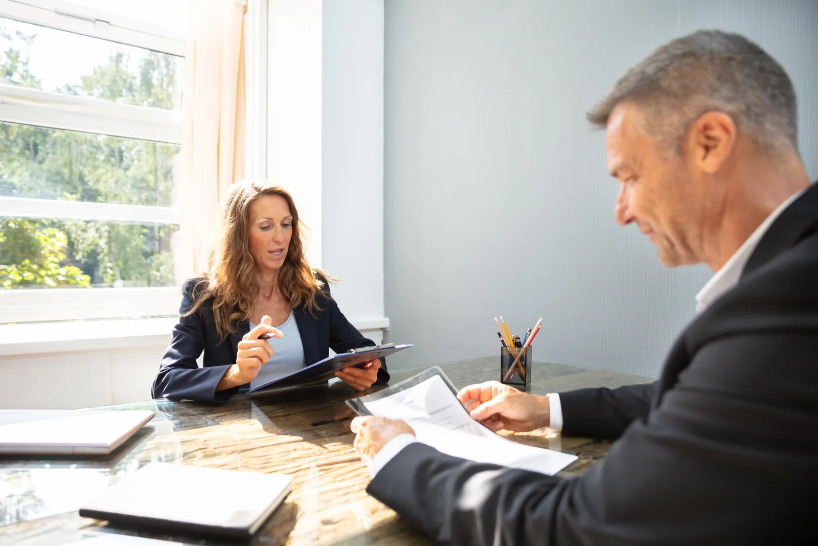 Personal injury attorney reviewing a rideshare trip receipt and accident photos with an injured Uber passenger at a law office conference table