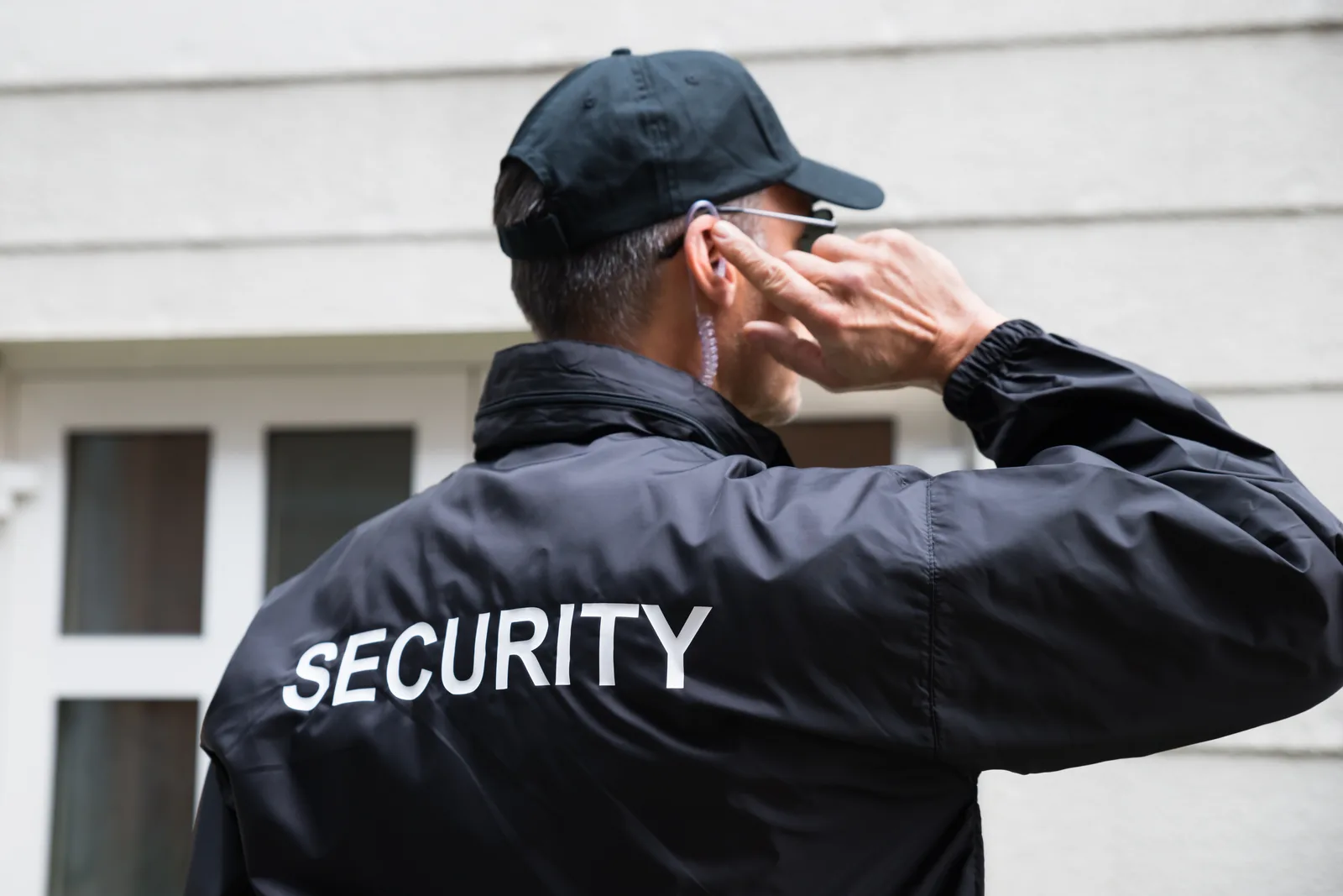 Uniformed security guard patrolling the exterior of a commercial building