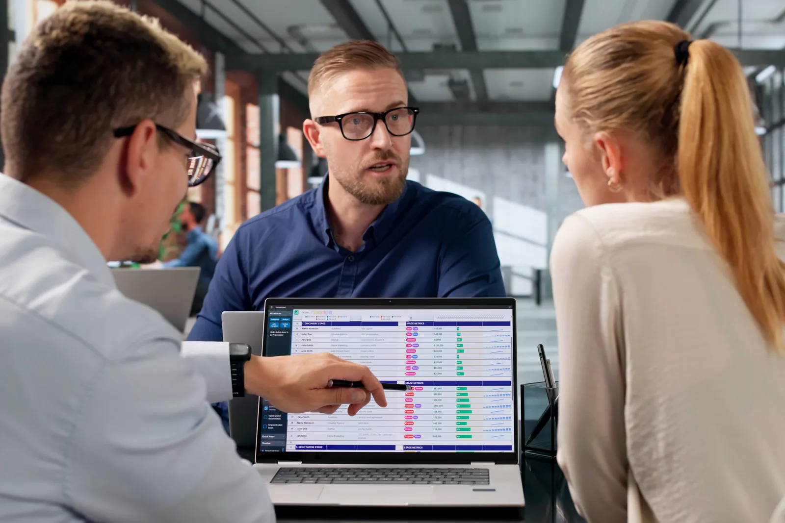 Software team reviewing a facility occupancy and unit-rental dashboard together at a laptop in their office