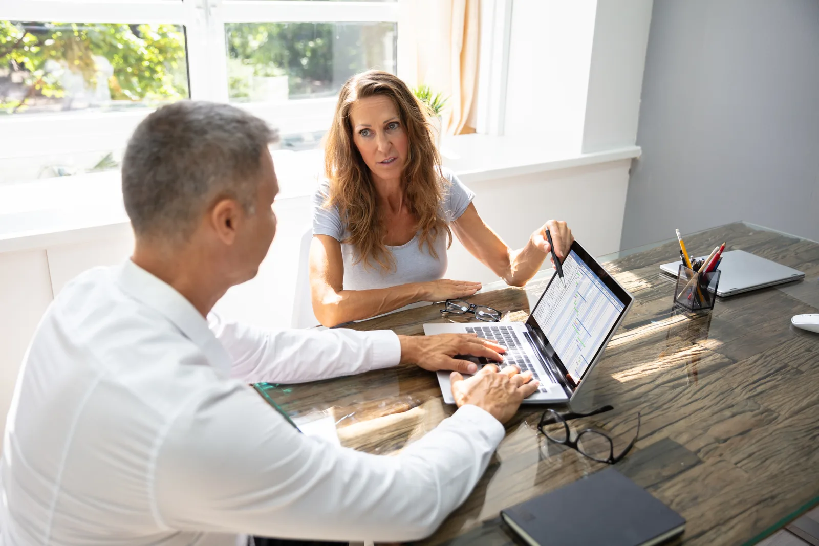 Senior living software product team reviewing a community occupancy and care dashboard together on a laptop in their office
