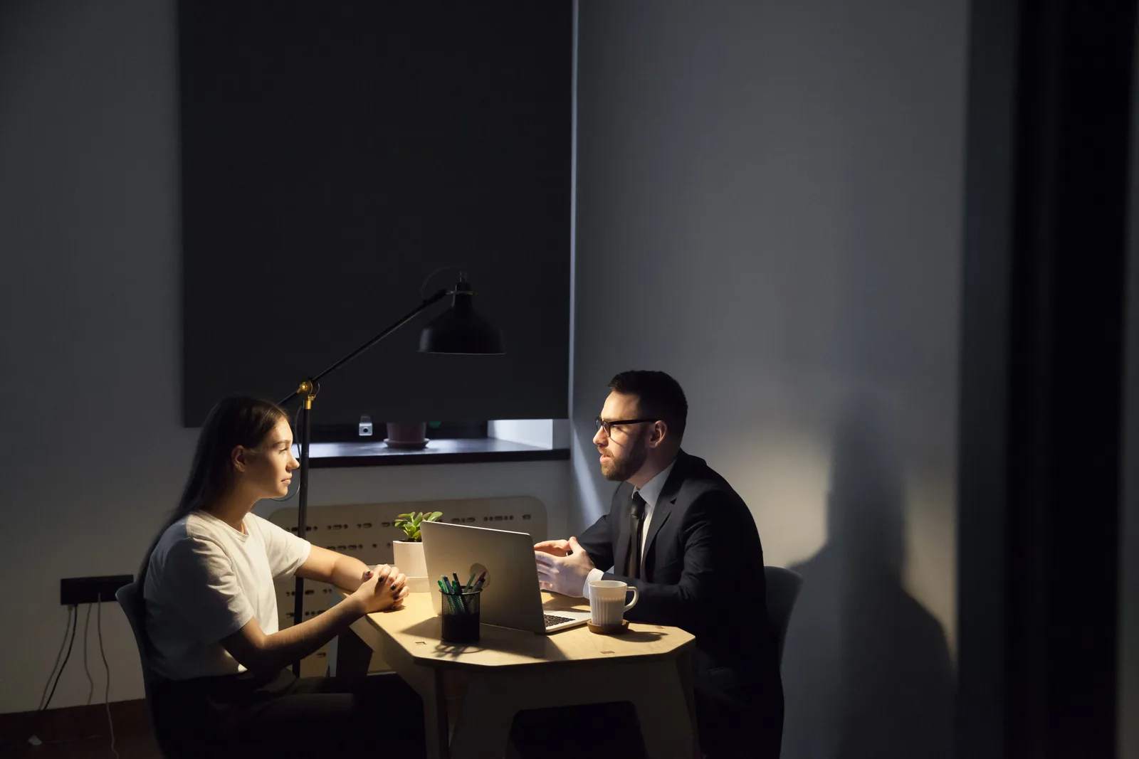 Sexual abuse attorney listening to a client during a private consultation in her office, a legal pad and box of tissues on the table between them