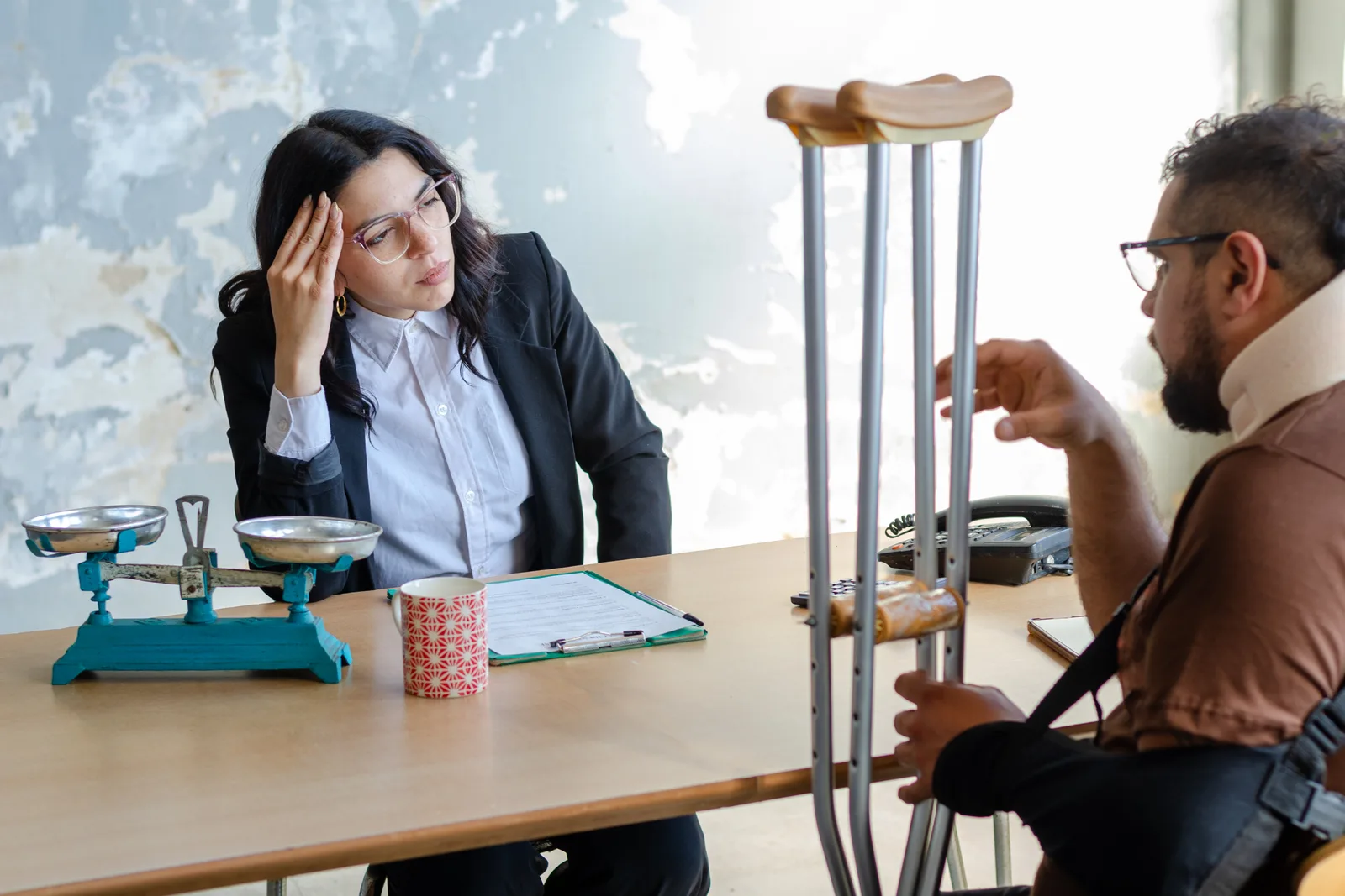 Attorney reviewing photos of a wet floor accident scene and medical records with an injured client at a law office conference table