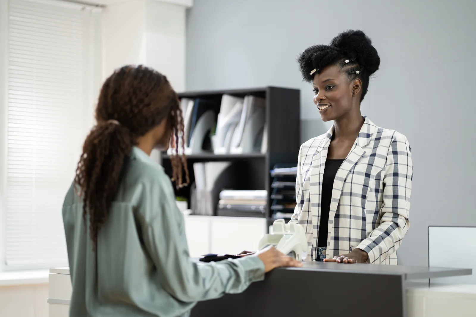 Tax preparer helping a customer review their refund at the counter of a seasonal tax preparation storefront