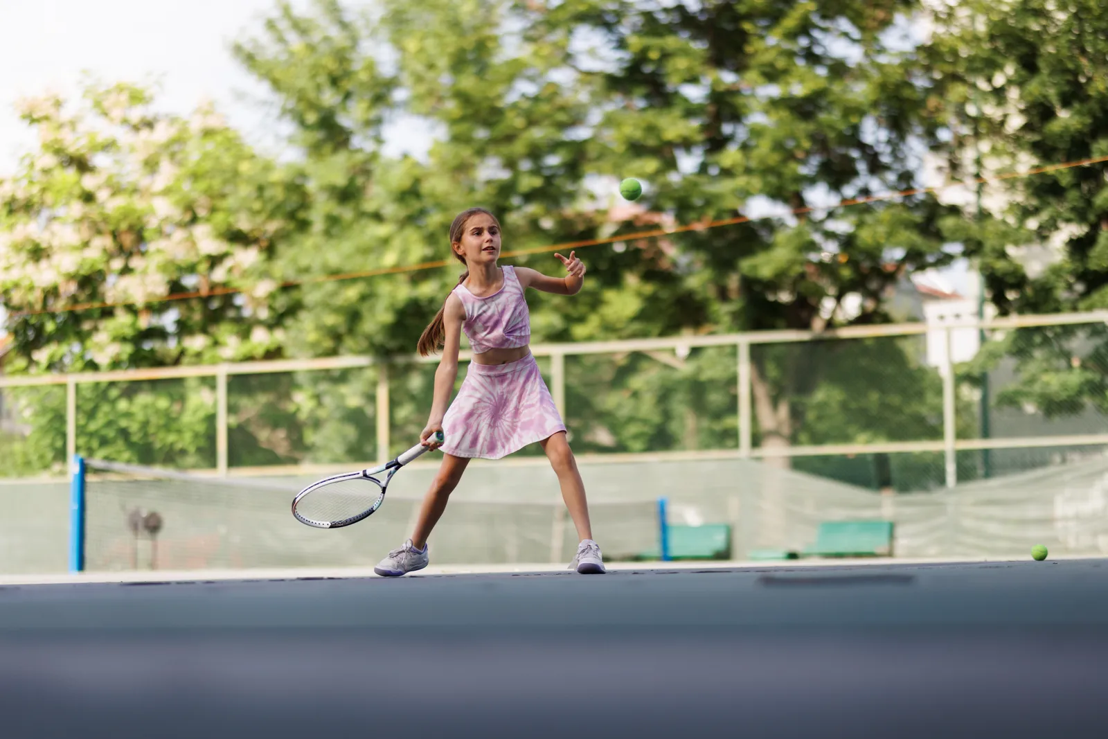 Junior player hitting a forehand during a lesson at a tennis academy
