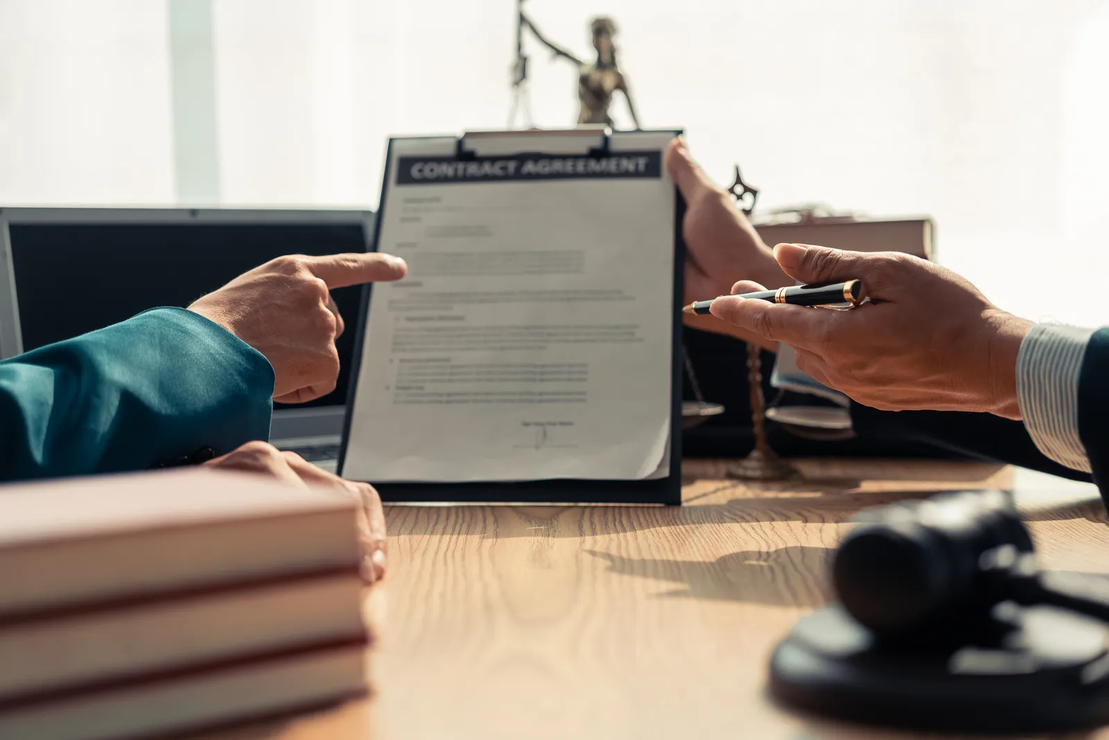 Timeshare exit attorney pointing out a clause in a timeshare contract while a client looks on at a law office desk