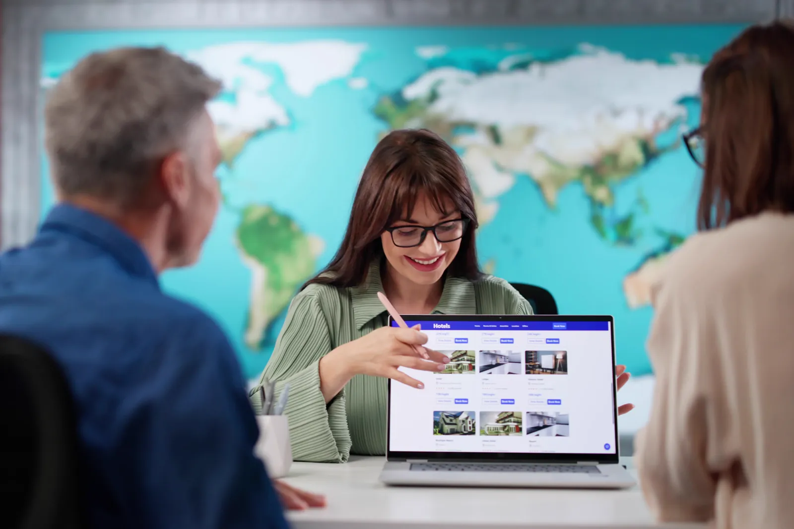 Travel booking app team reviewing trip-booking and conversion data together at a laptop in their office