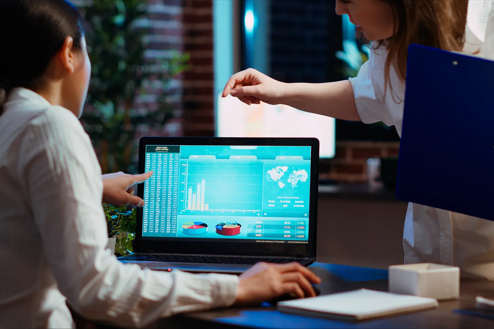 Treasury and finance team reviewing a real-time cash-position dashboard together at a laptop in their office