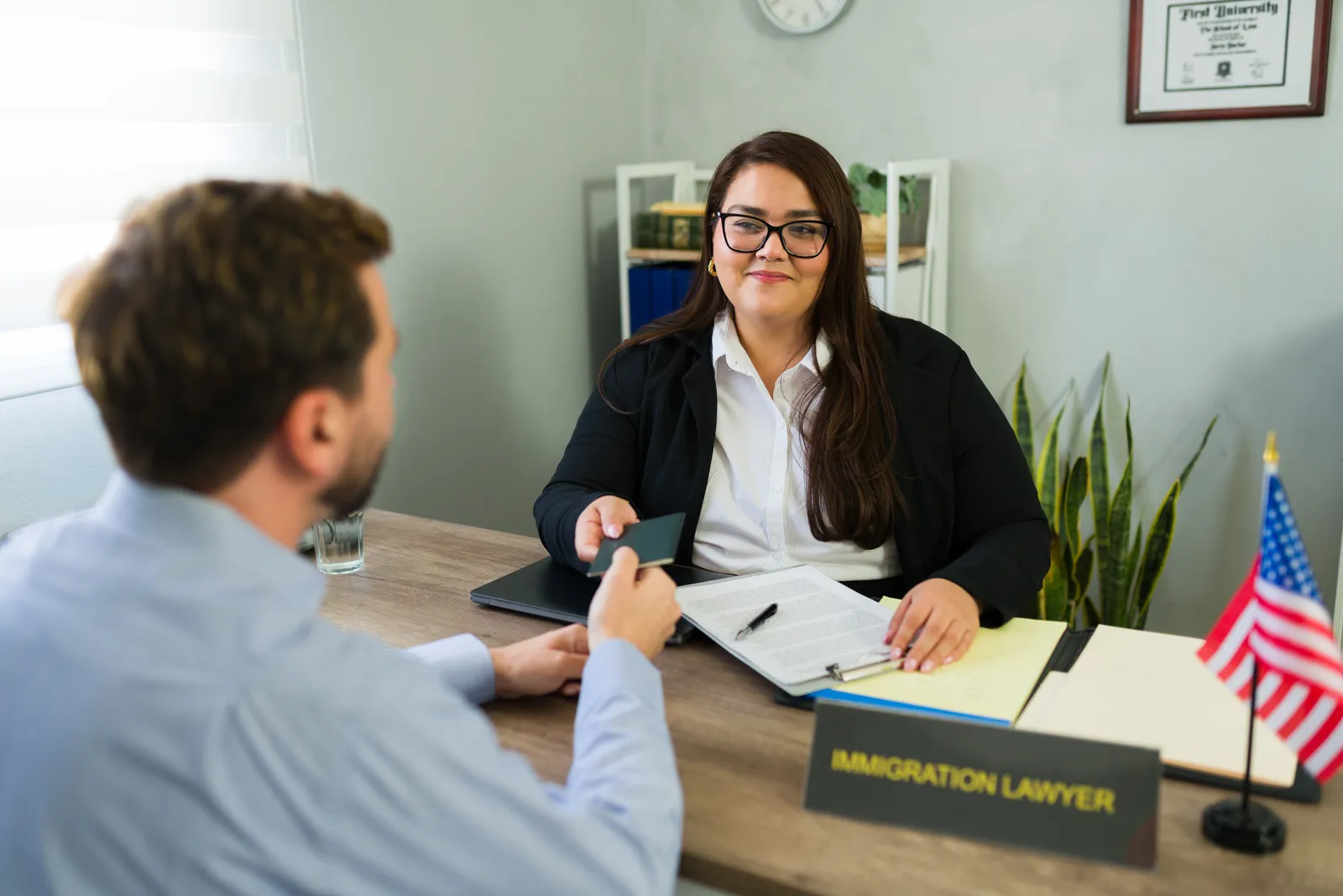 Immigration attorney speaking privately with a client across her desk about a confidential U-visa or VAWA case
