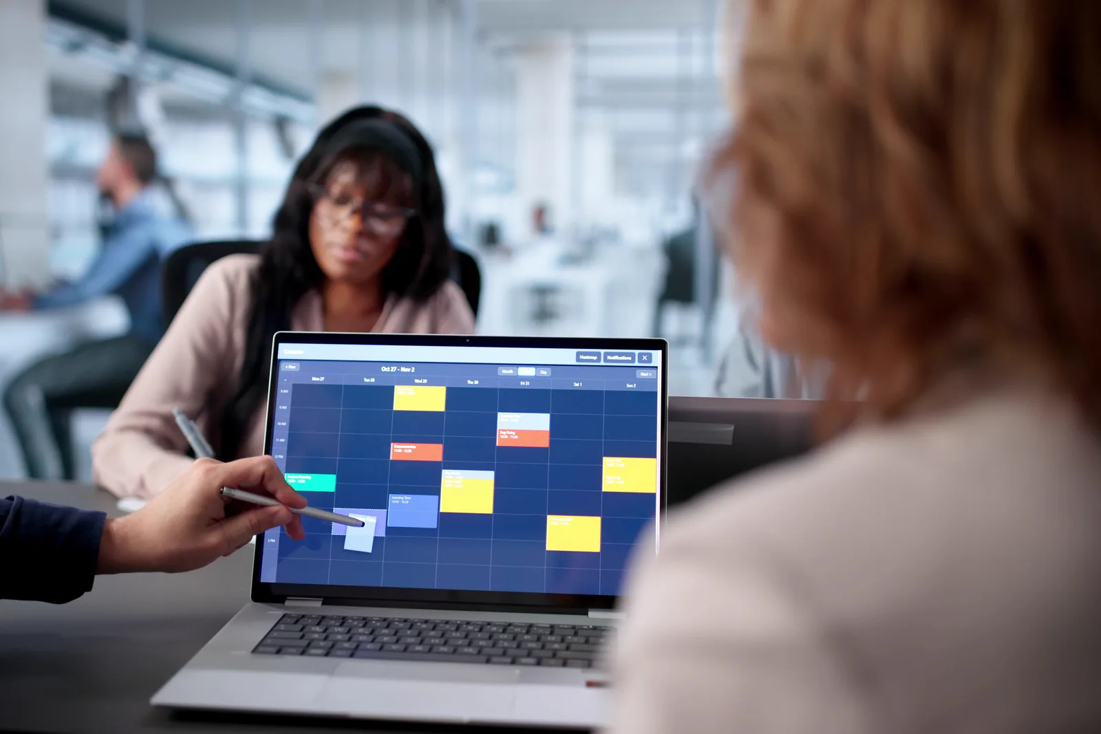 Vacation rental software product team reviewing synced Airbnb, Vrbo & Booking.com calendars on a laptop dashboard in their office