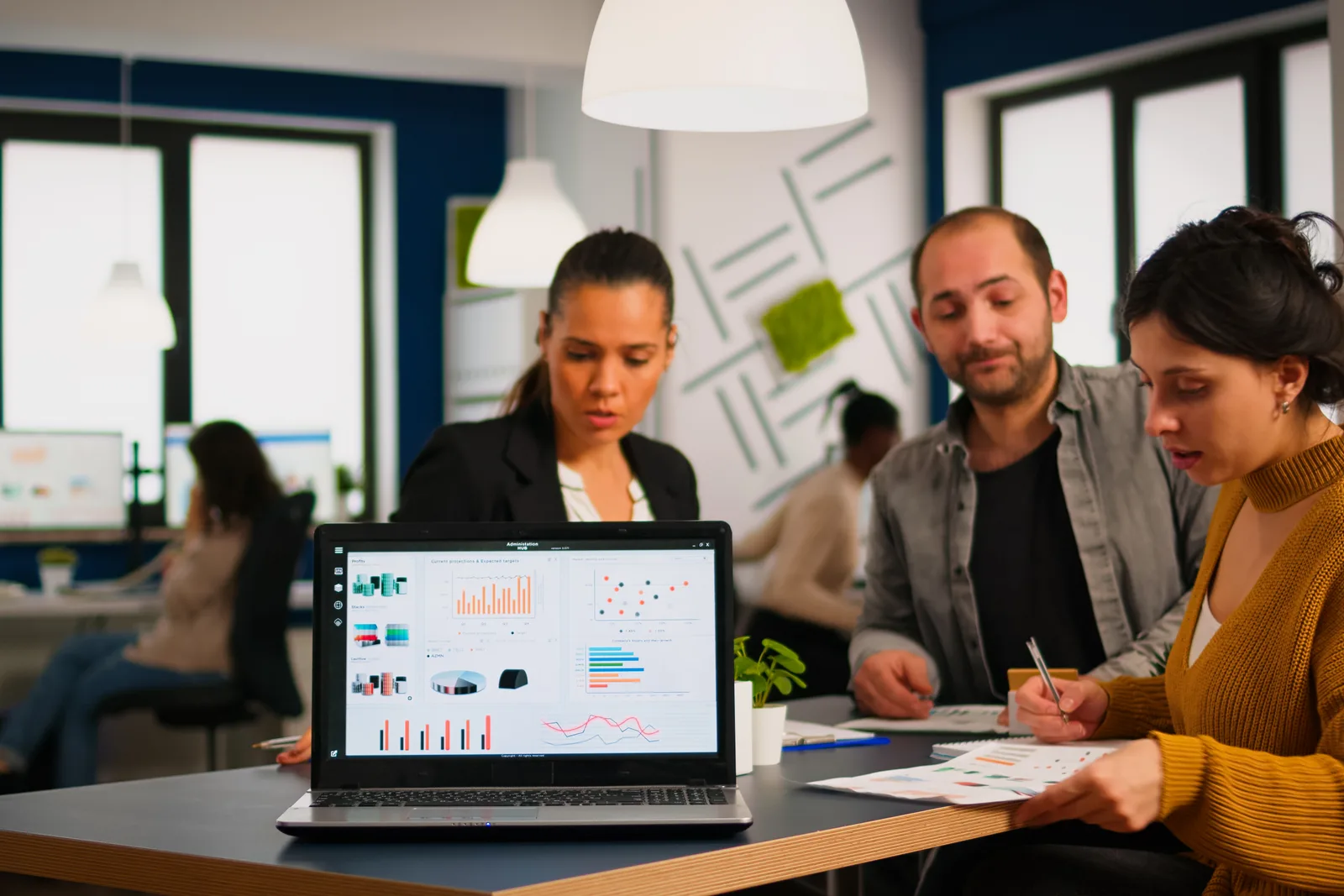 Vertical SaaS team reviewing customer signup and activation dashboards together on a laptop