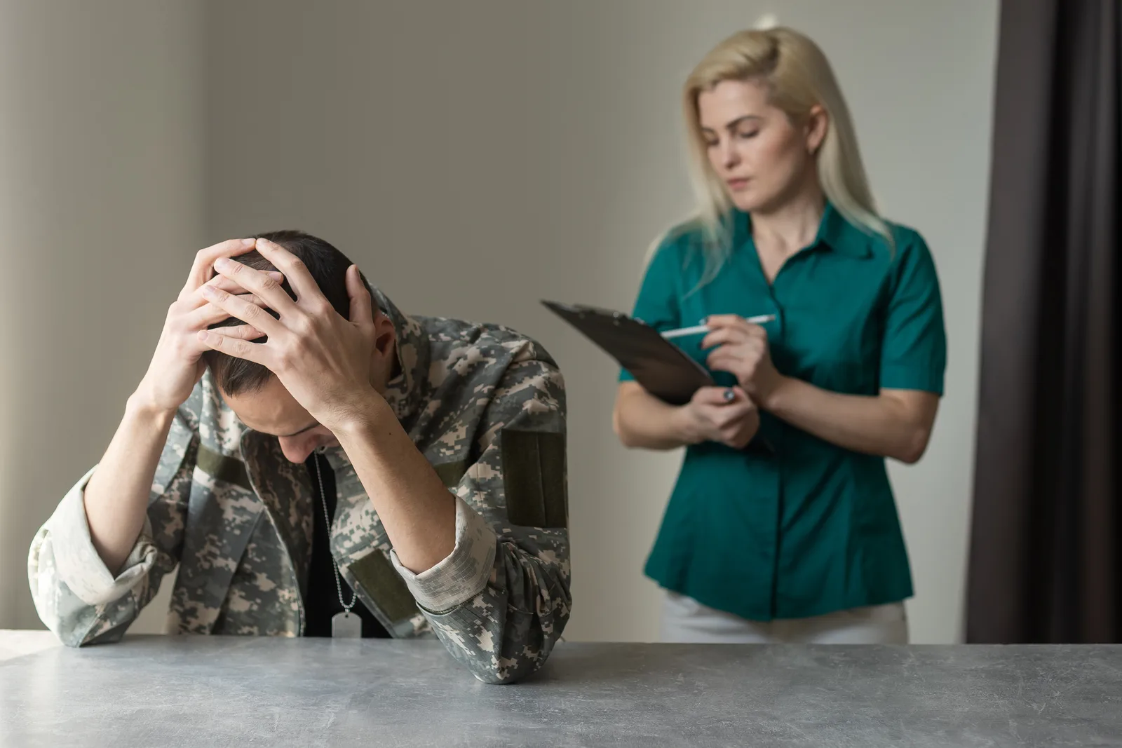 Veterans disability attorney reviewing VA claim paperwork with a veteran client at her office desk