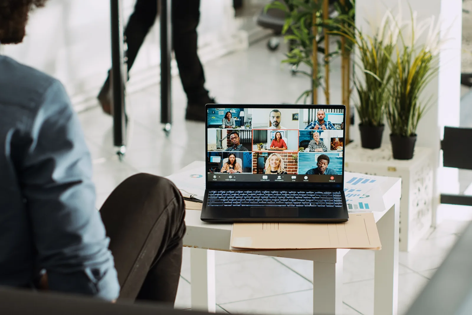 Video conferencing software team reviewing meeting-quality and platform adoption dashboards together at a laptop in their office