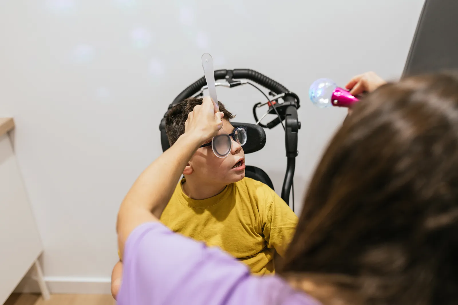 Vision therapist guiding a child through an eye-tracking exercise during a vision therapy session