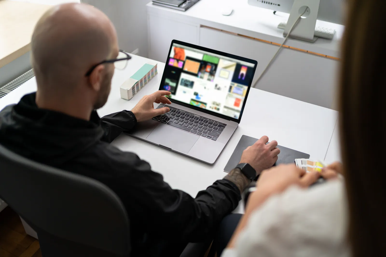Webflow template designer reviewing a live template preview and marketplace sales analytics on a laptop at a design studio desk