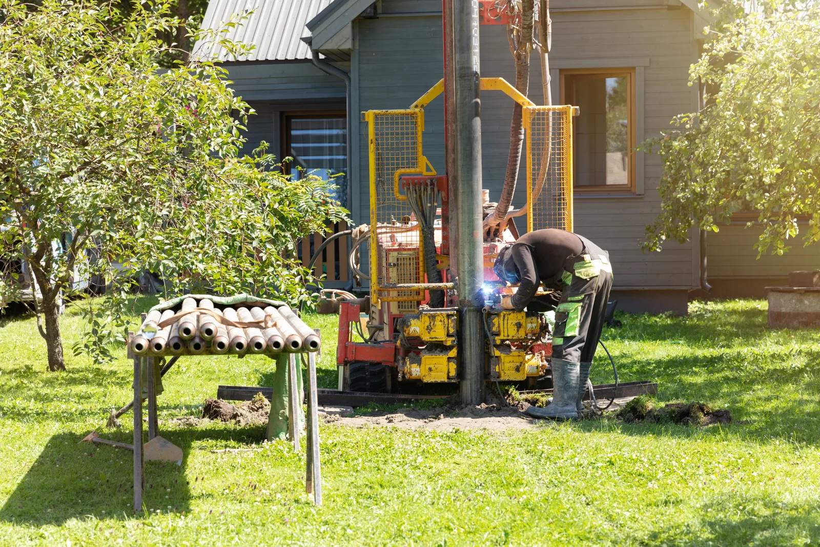 Drilling rig crew boring a new residential water well on a rural property