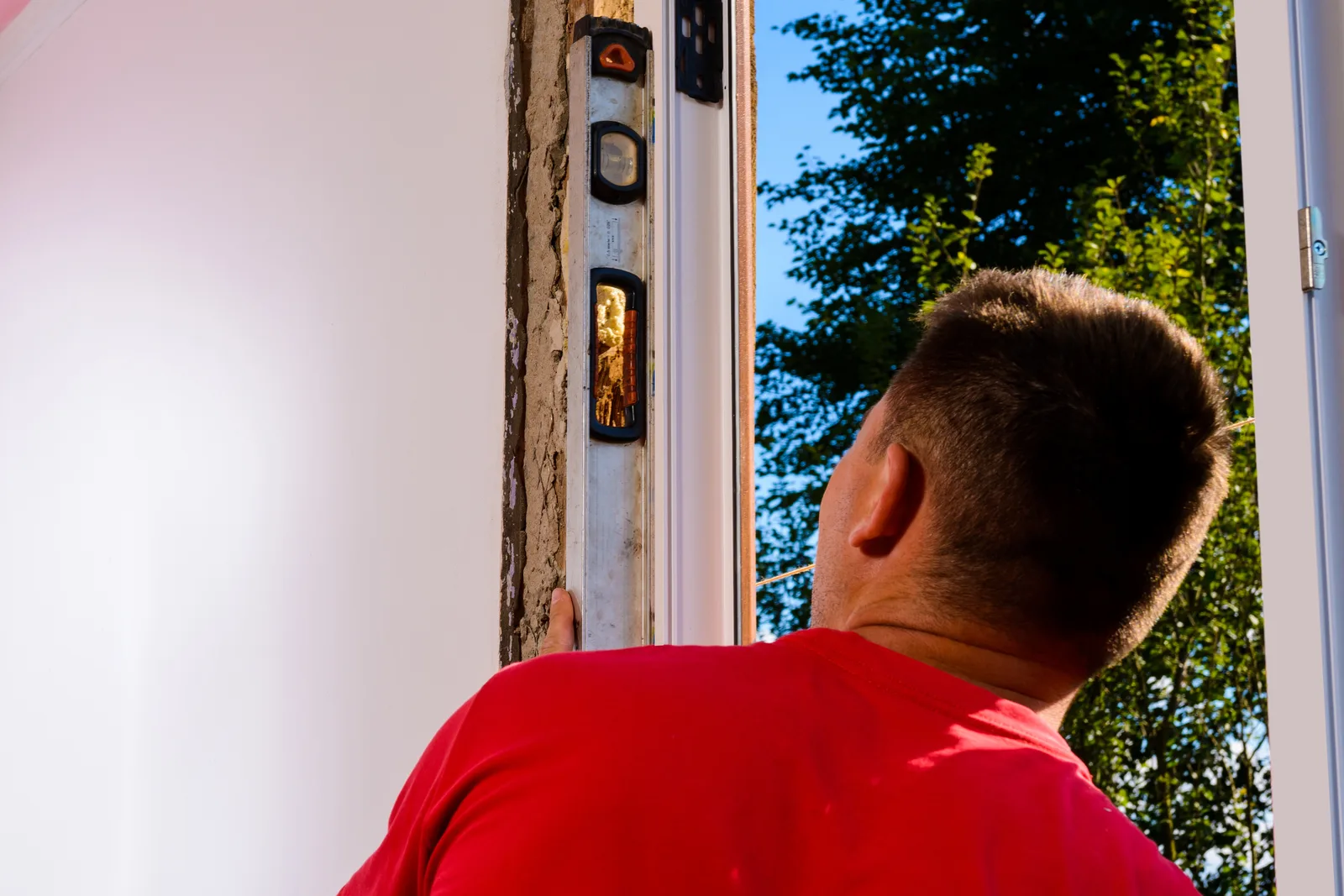 Installer fitting a new replacement window into a prepared opening at a customer's home