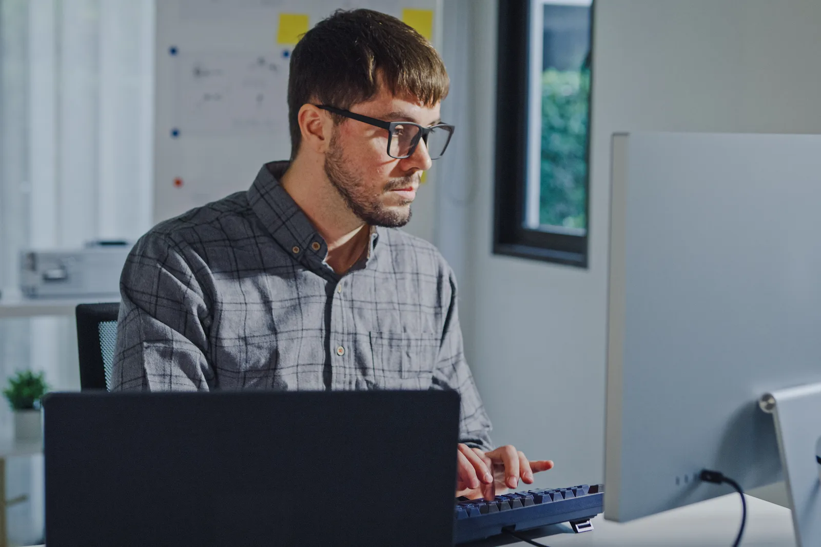 WordPress plugin developer reviewing install and upgrade metrics on a laptop at a desk